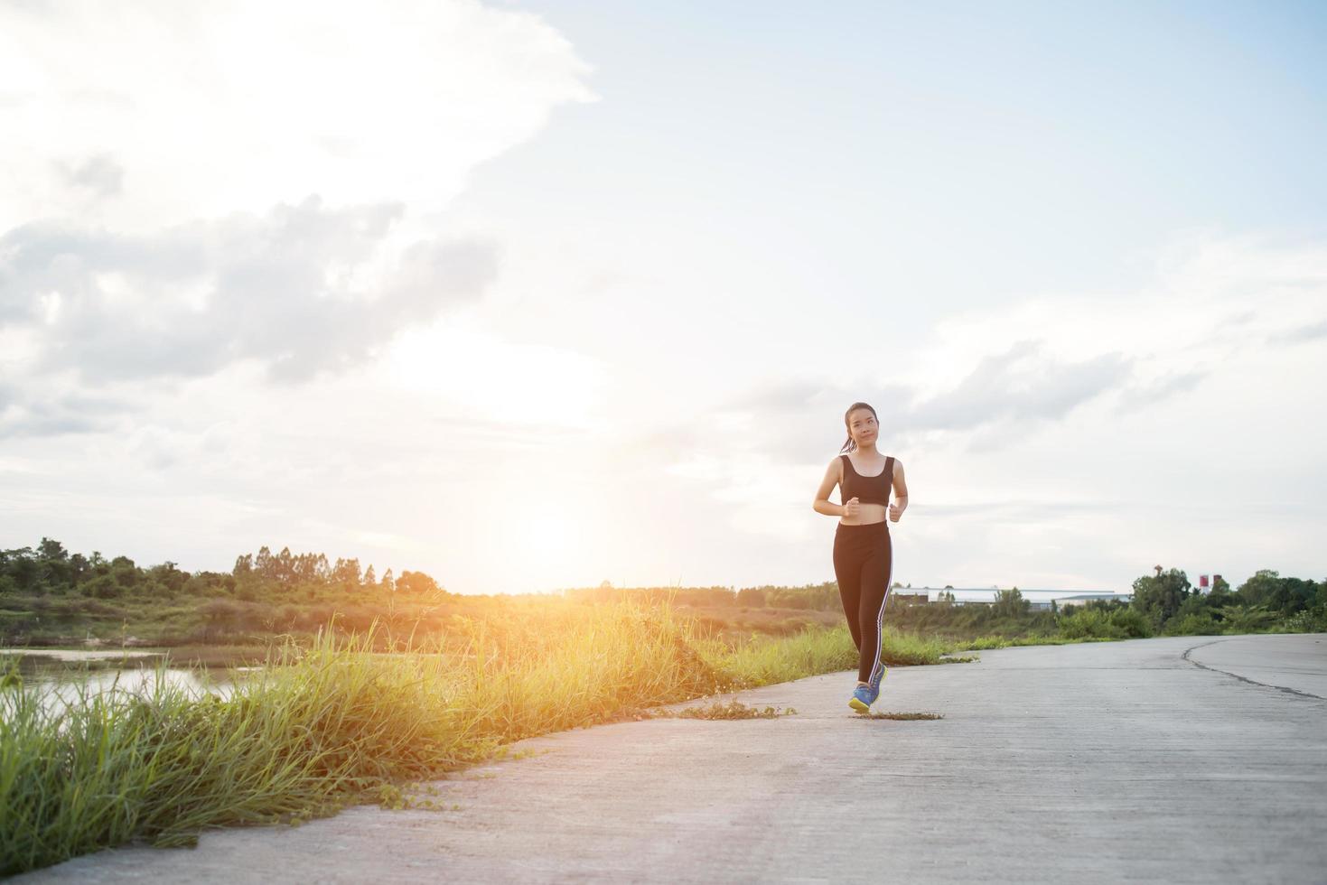 eine junge glückliche Läuferin, die draußen joggt foto