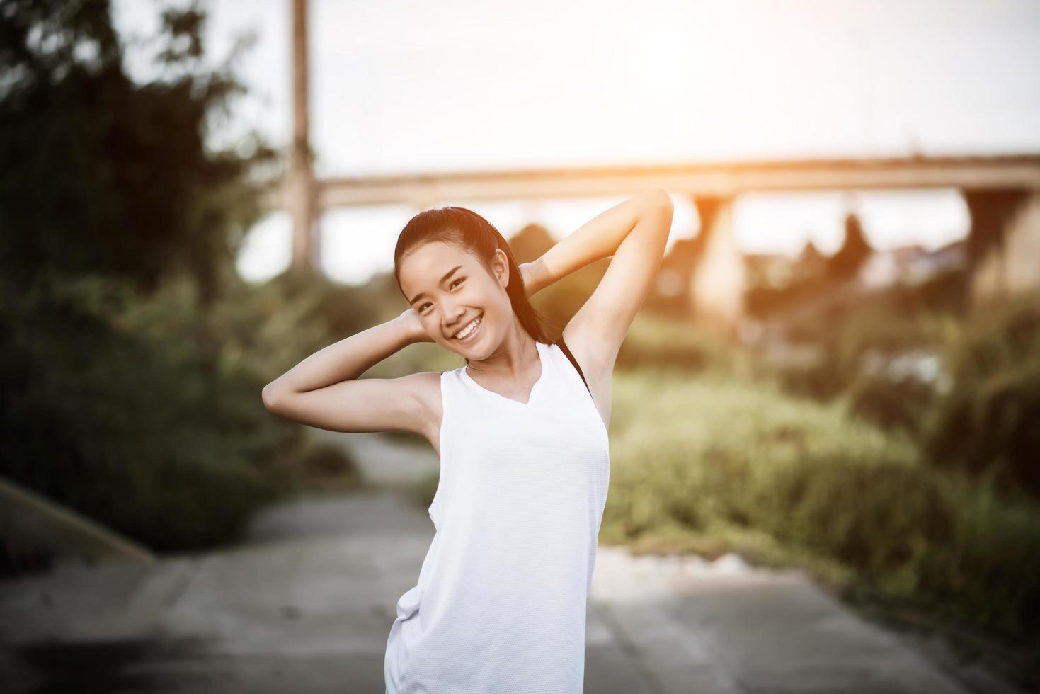 gesunde junge Frau, die sich im Freien für das Training aufwärmt foto