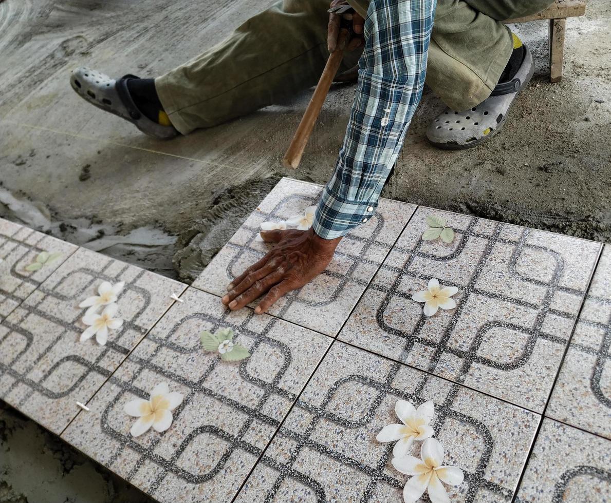 Die Hand des Arbeiters klebt Fliesen foto