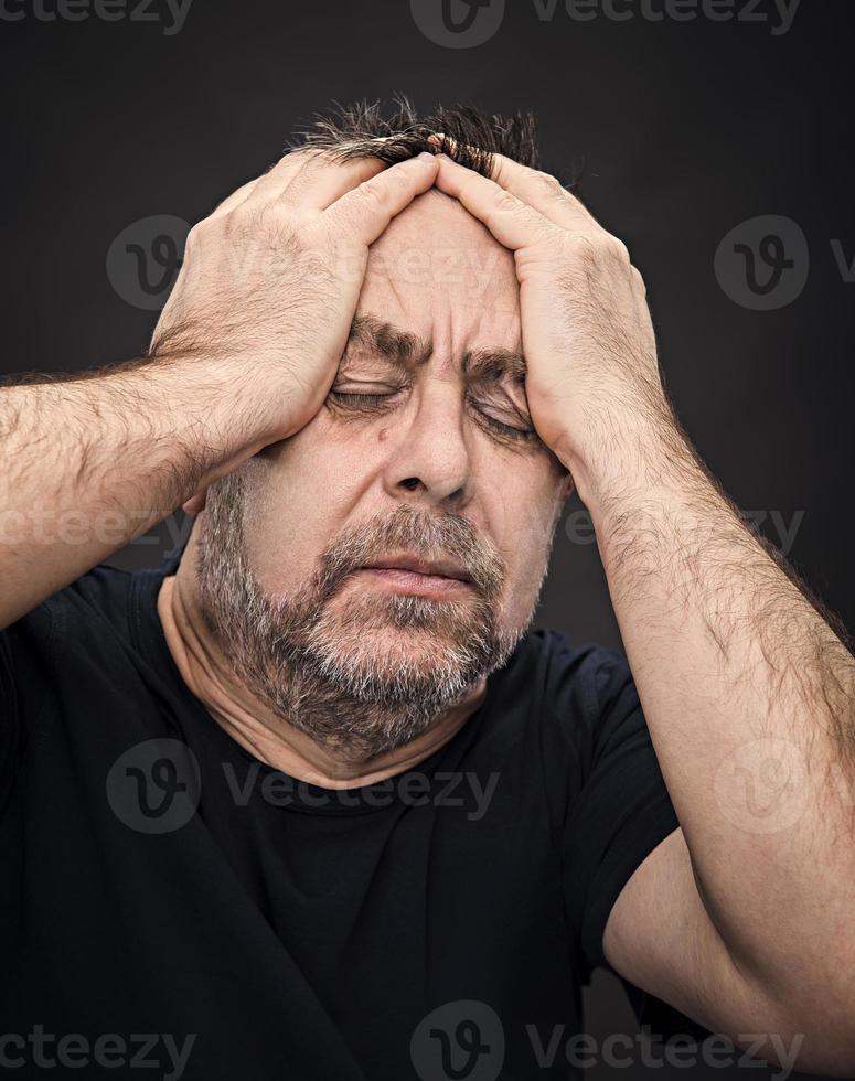 Kopfschmerzen. Mann mit Gesicht von Hand geschlossen foto