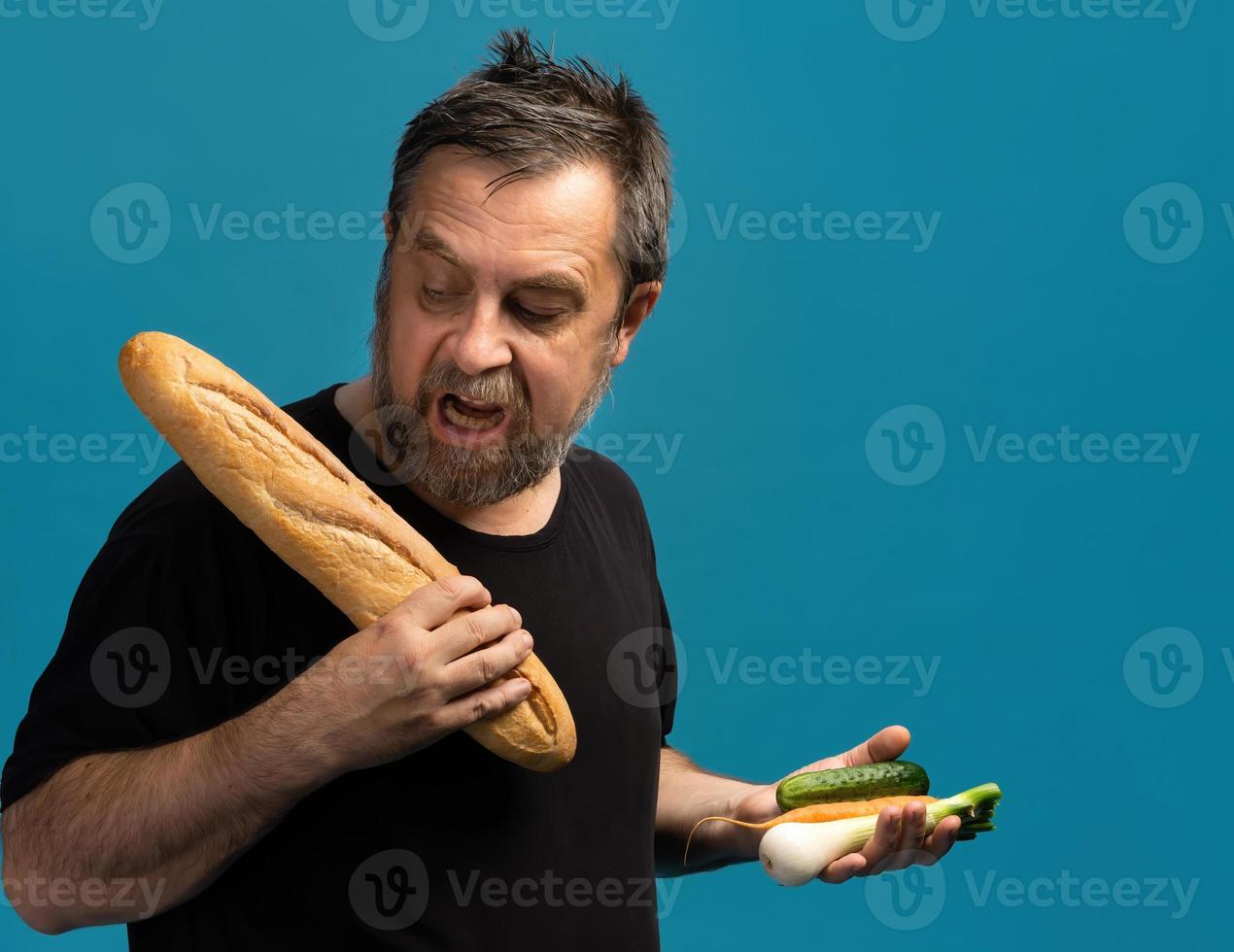 Mann hält Gemüse in der einen Hand und Brot in der anderen foto