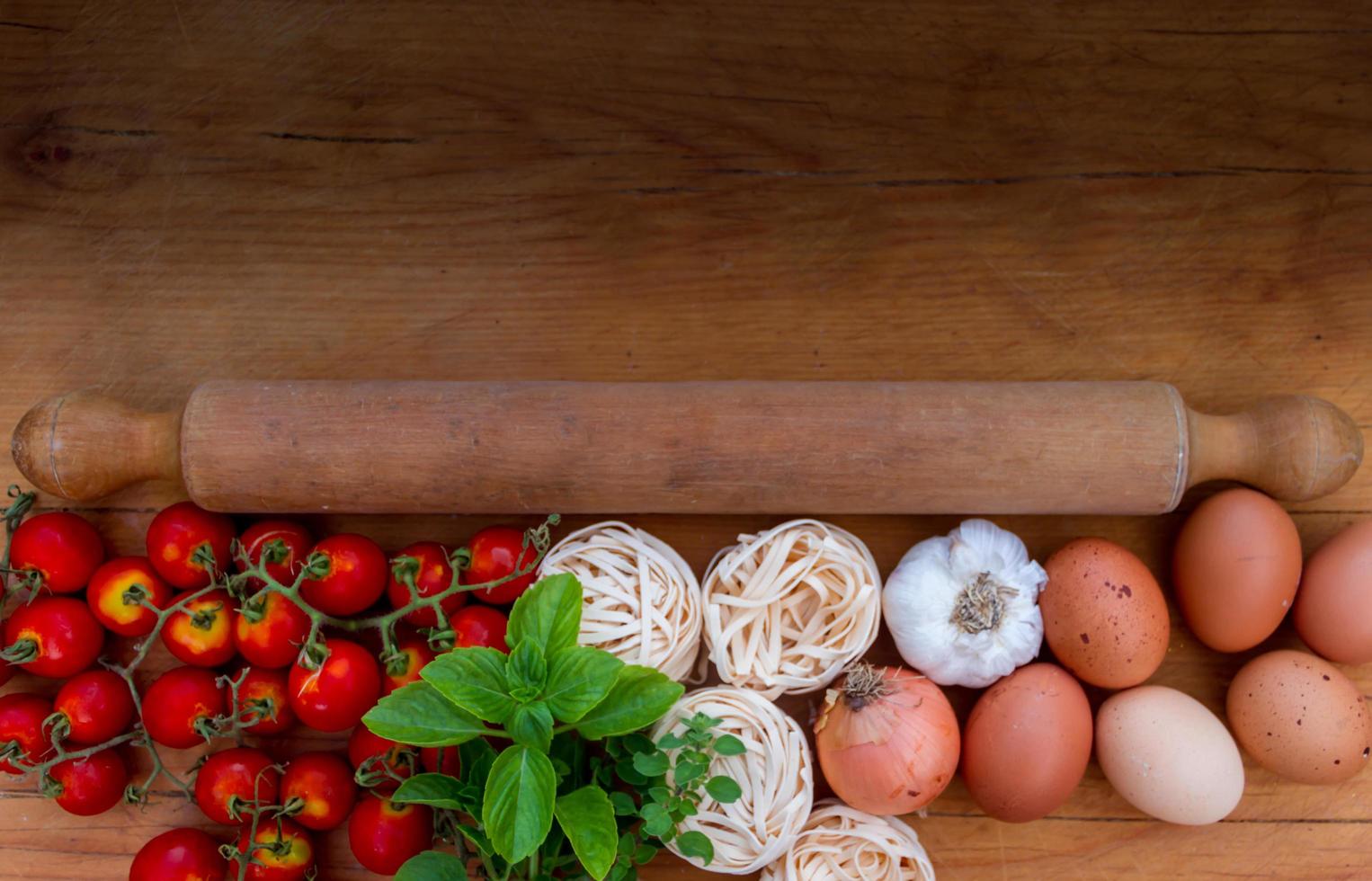 Hintergrund Zutaten Küche Draufsicht mit Nudeln, Eiern, Tomaten und frischen Kräutern foto