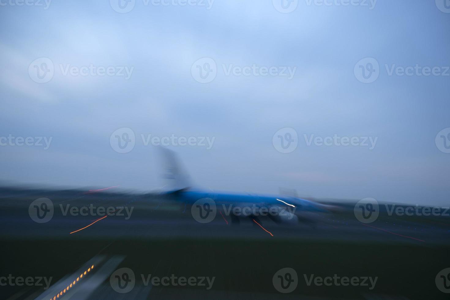 Flughafenlichter in Bewegung, während das Flugzeug nachts abhebt foto