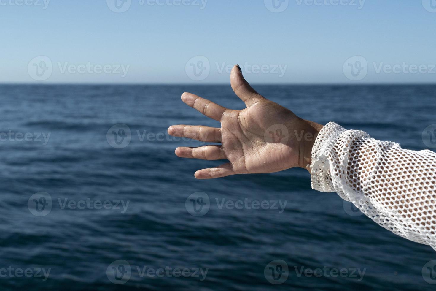 Schwarze Frauenhand auf dem Meereshintergrund foto