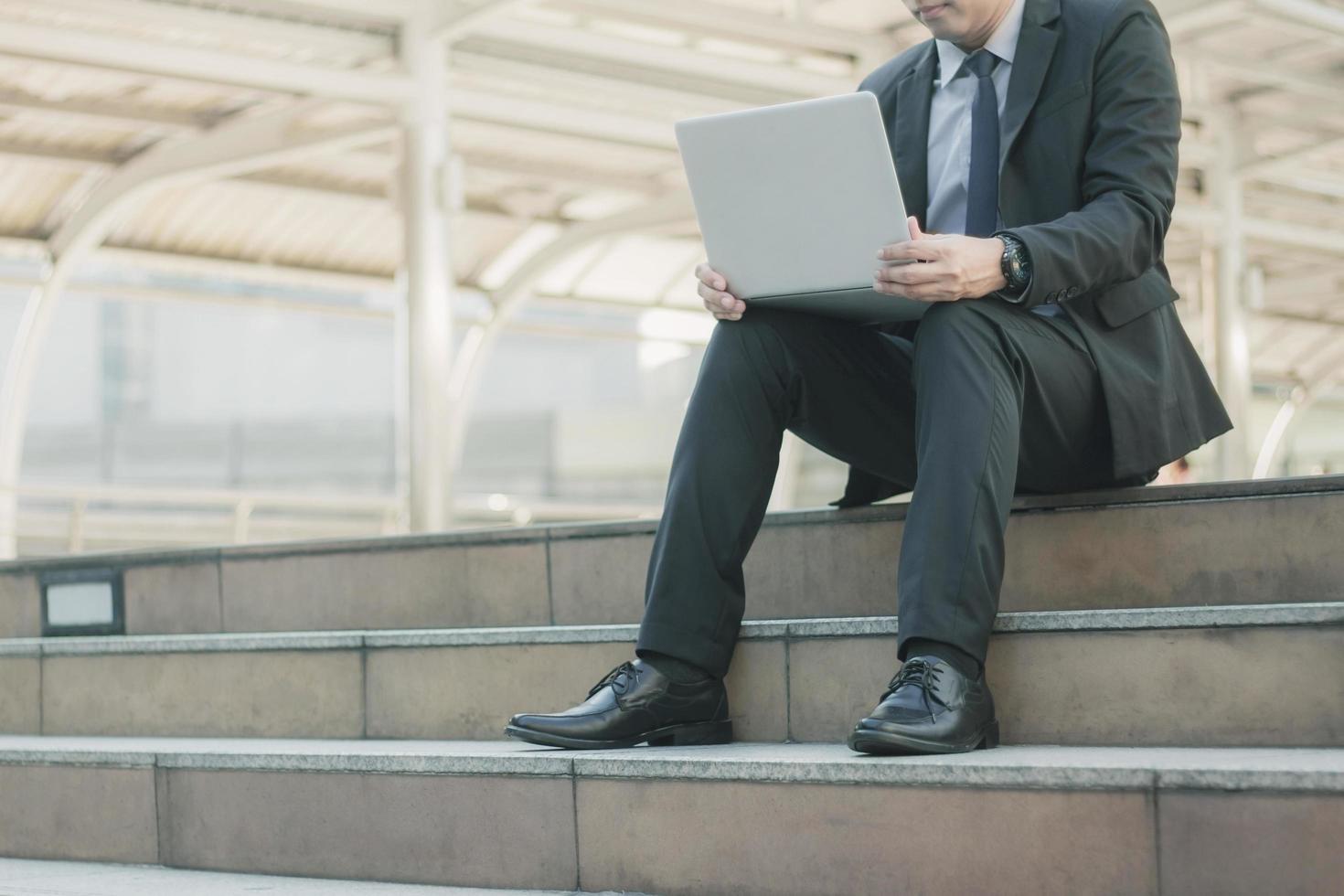 Mann mit Laptop auf der Treppe. foto