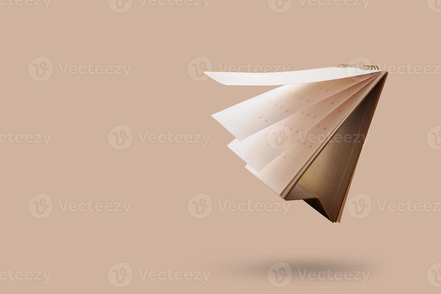 Weißbuch-Tischkalender, der die Seite einzeln auf braunem Hintergrund umblättert foto