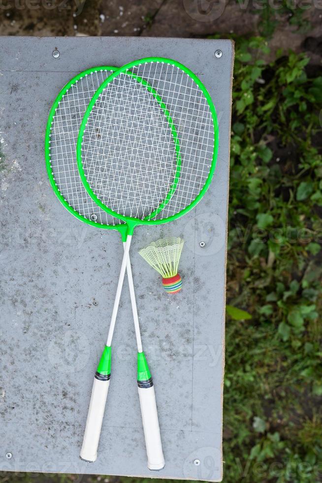 grüne Badmintonschläger auf dem Tisch. Sport im Freien, aktive Erholung. Sicht von oben. Sportausrüstung. foto
