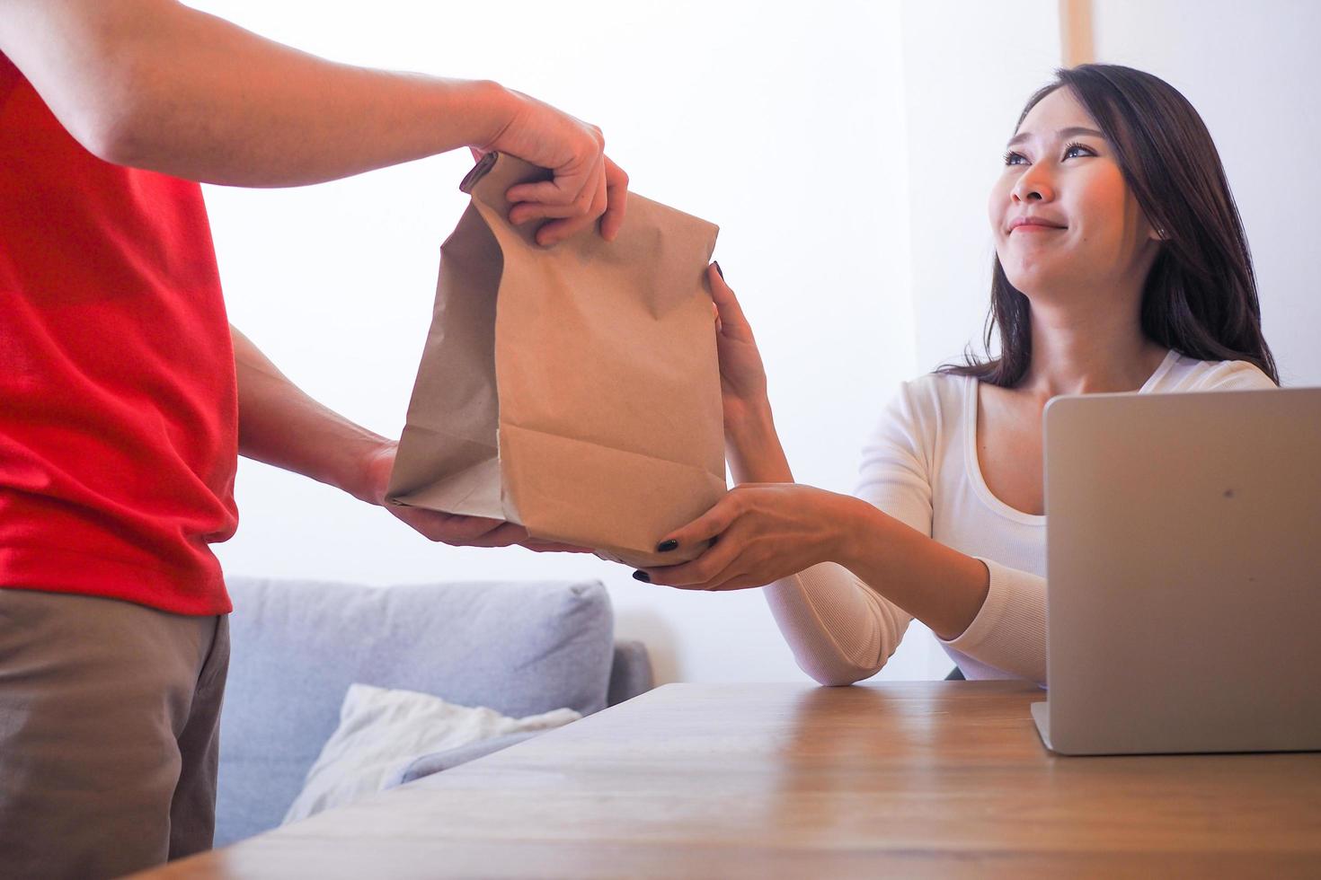 asiatische Frauen sind glücklich, nachdem sie Papiertüten für Lebensmittel erhalten haben, nachdem sie angerufen haben, um Lebensmittel online zu bestellen. foto