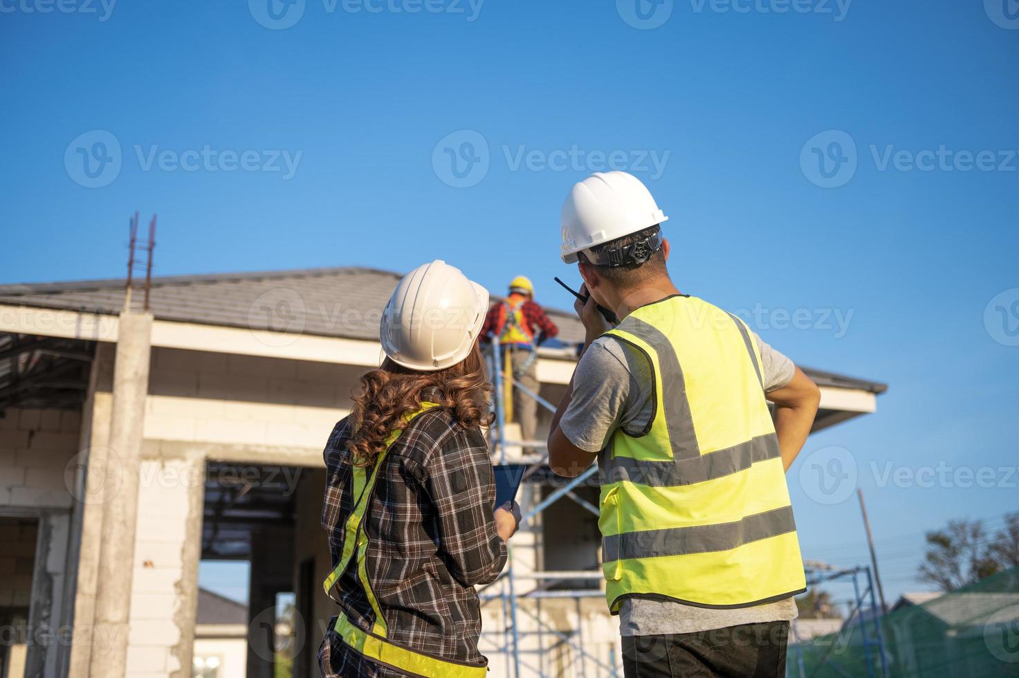 bauinspektor und architektin diskutieren mit chefingenieur asien über die installation von sonnenkollektoren bei einem bauprojekt. Besuchen Sie die Baustelle, um Sonnenkollektoren zu installieren. foto