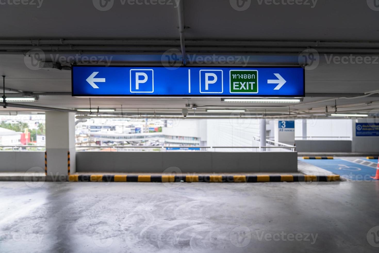 Beschilderungs-Beleuchtungskasten in der Tiefgarage, dem Fahrer mitteilen, in welche Richtung der Parkplatz oder die Ausfahrt führt. Thailändische Sprache im grünen Quadrat auf Lightinbox bedeutet Ausgang. foto