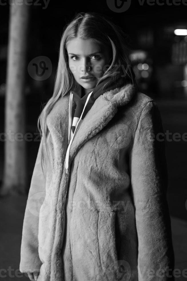 Schwarz-Weiß-Porträt eines Mädchens vor dem Hintergrund einer nächtlichen Stadt foto