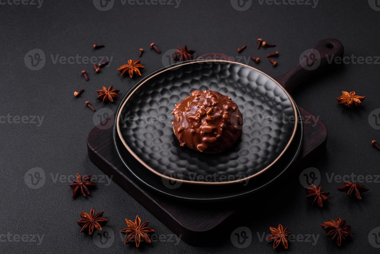 Köstliche Schokoladentarte mit Nüssen auf einer schwarzen Keramikplatte foto