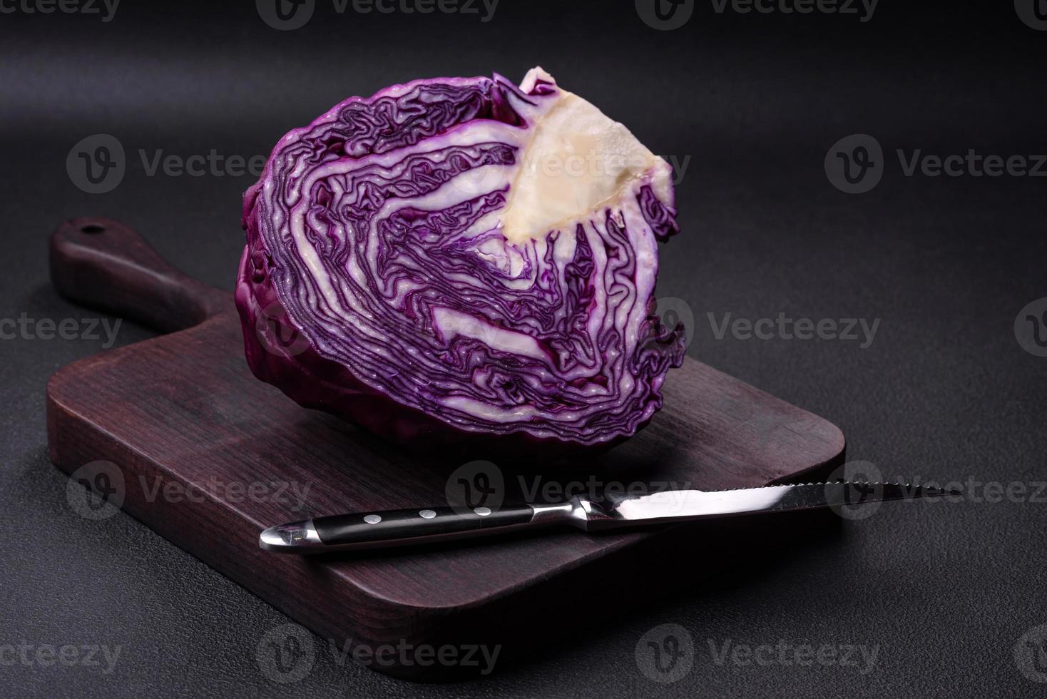 frischer schöner rotkohl mit strukturierten blättern auf einem dunklen betonhintergrund foto