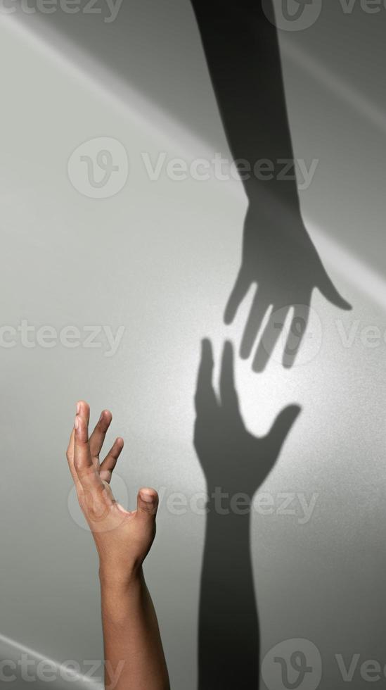 helfende hand, unterstützung oder partnerschaftskonzept. schatten einer helfenden hand zur rettung einer katastrophenperson. Geschäft und Beziehung von Menschen foto