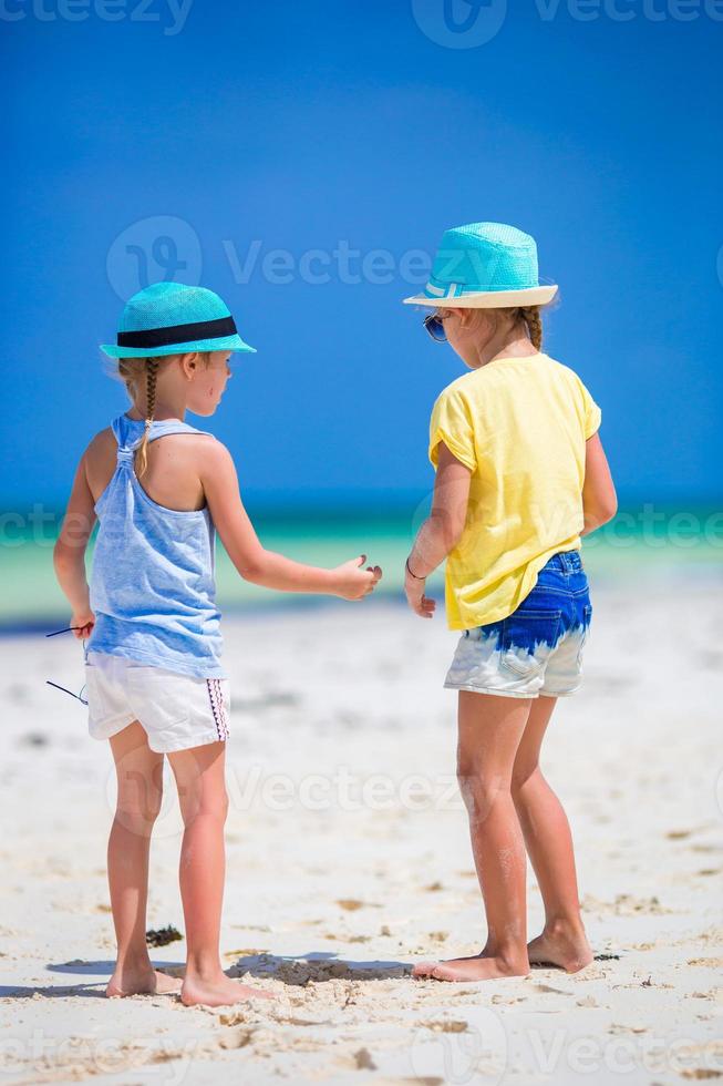 Entzückende kleine Mädchen am Strand während der Sommerferien foto
