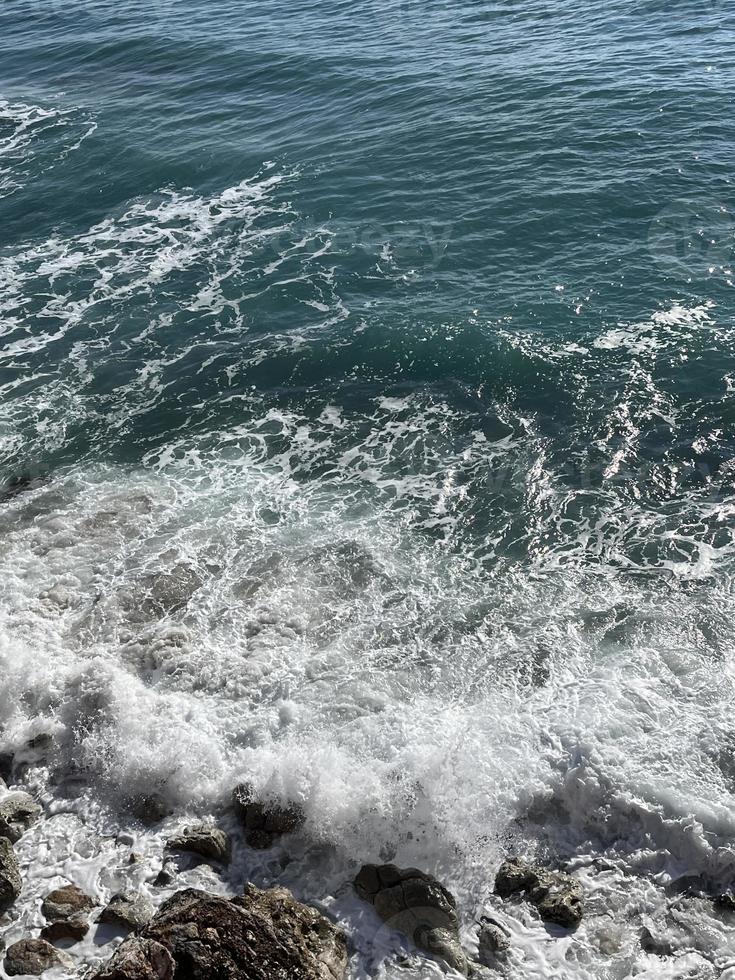 die Wellen im Meer krachen gegen die Felsen foto