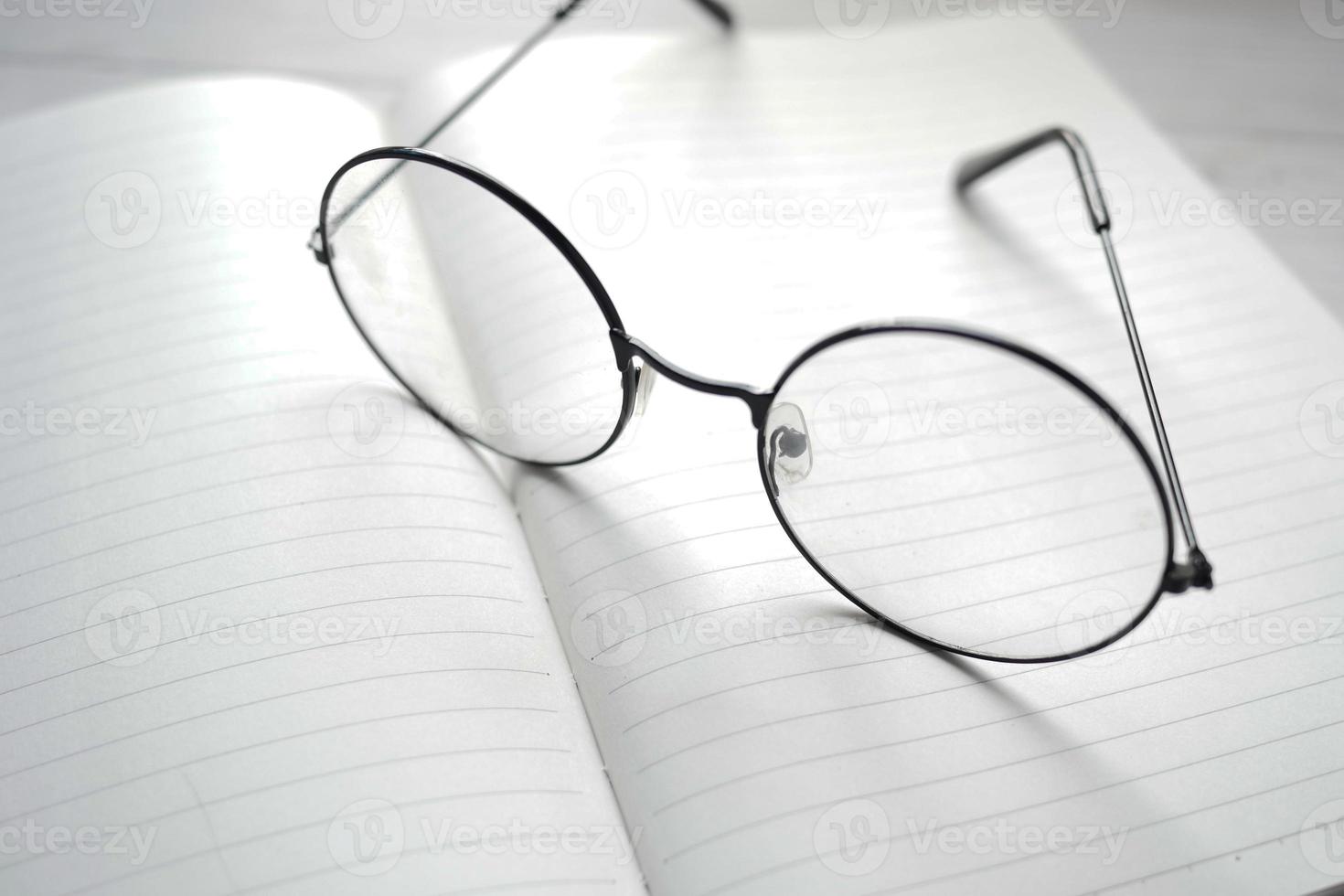 Notizblock, Brille und Bleistift auf Holztisch foto