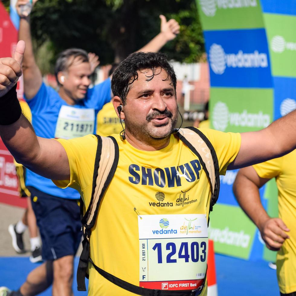 neu delhi, indien - 16. oktober 2022 - vedanta delhi halbmarathonrennen nach covid, bei dem die marathonteilnehmer kurz vor dem überqueren der ziellinie stehen, delhi halbmarathon 2022 foto