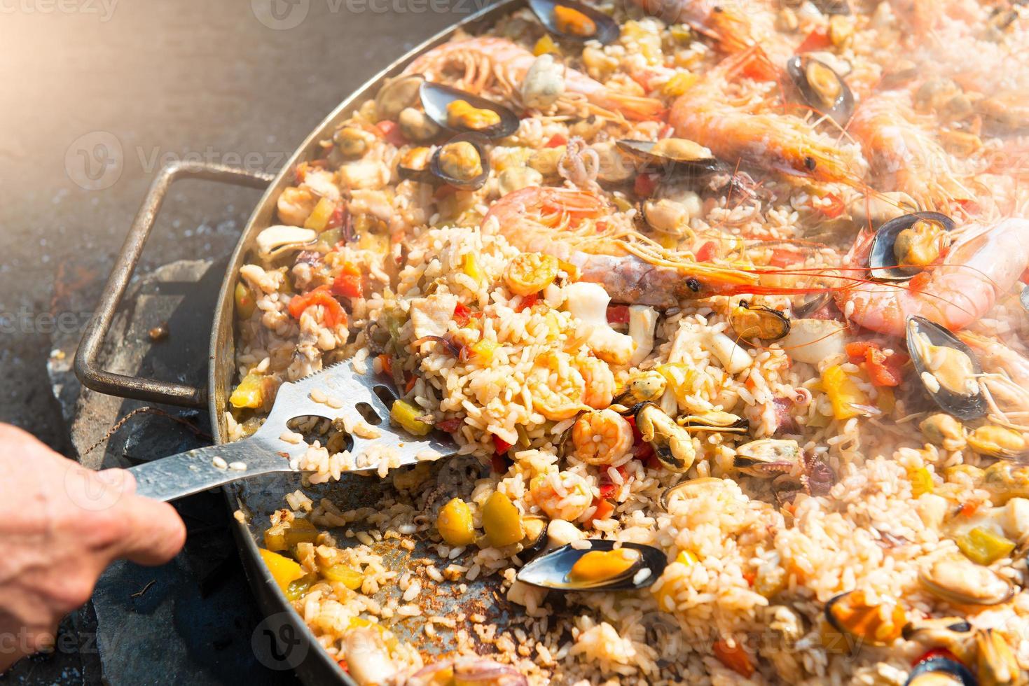Zubereitung von Paella-Reis und Fisch foto