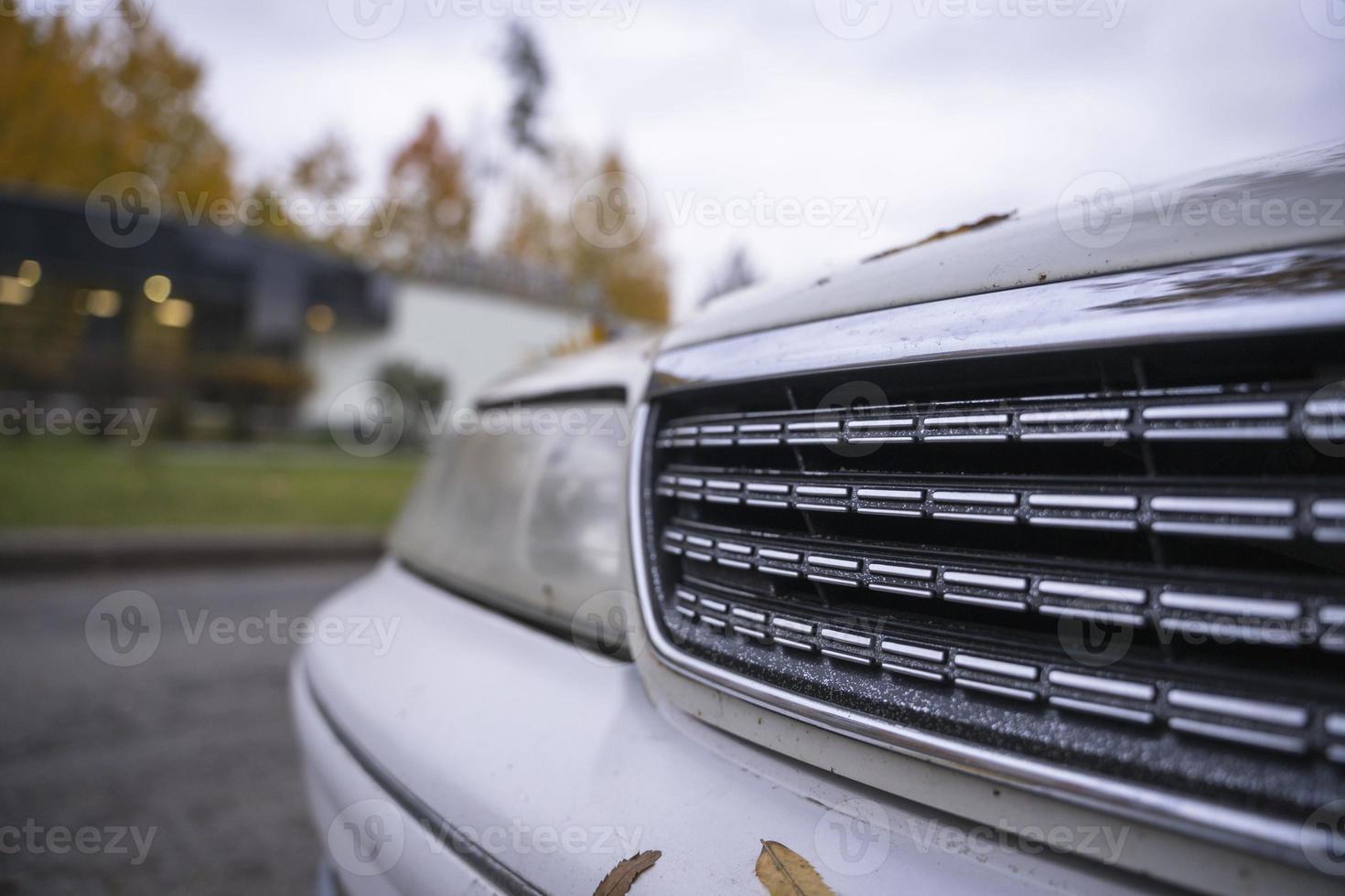 Der Kühlergrill eines klassischen japanischen Autos in einer herbstlichen Stadtlandschaft, einer beliebten in Japan hergestellten Limousine foto