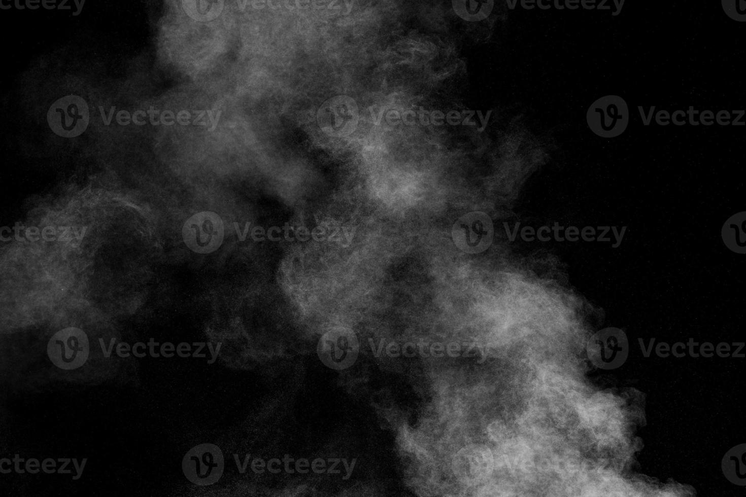 weiße Staubwolke in der Luft. Abstrakte weiße Pulverexplosion vor schwarzem Hintergrund. foto