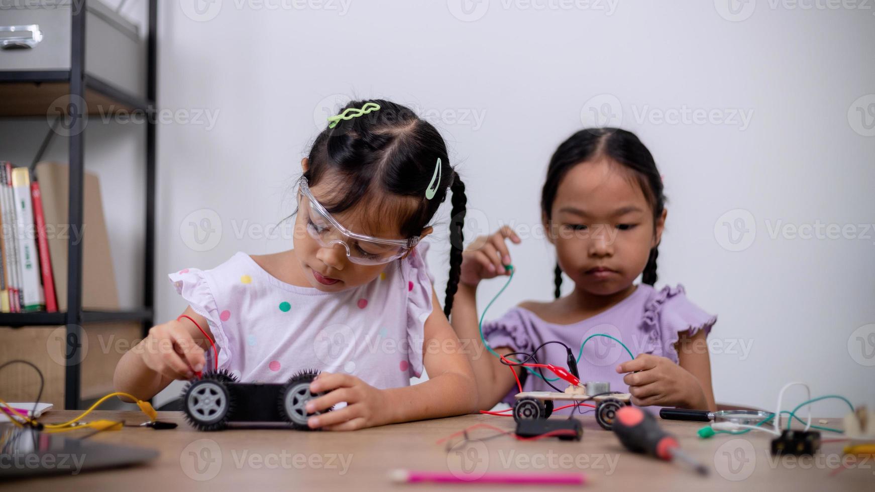 asiatische schüler lernen zu hause, indem sie roboterautos und elektronische platinenkabel in stamm, dampf, mathematik, ingenieurwesen, wissenschaft, technologie, computercode in robotik für kinderkonzepte codieren. foto