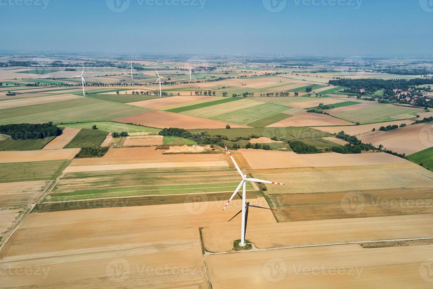 windmühlenturbine im feld am sommertag. drehender Windgenerator foto