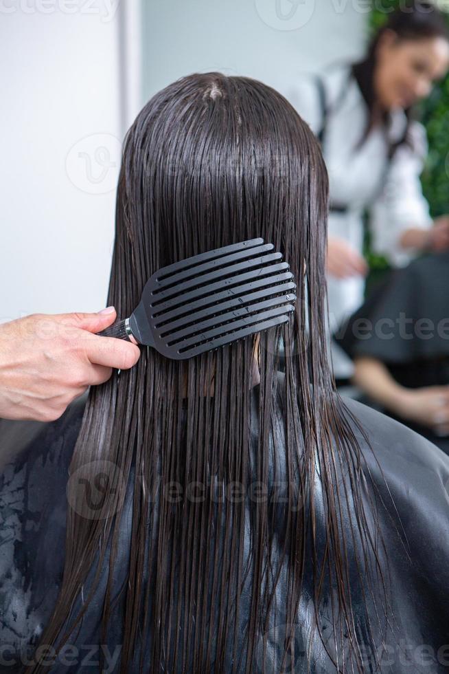 professioneller friseur, der haare der jungen frau im schönheitssalon wäscht. nahaufnahme des haares der frau im schönheitssalon, frisurkonzept foto