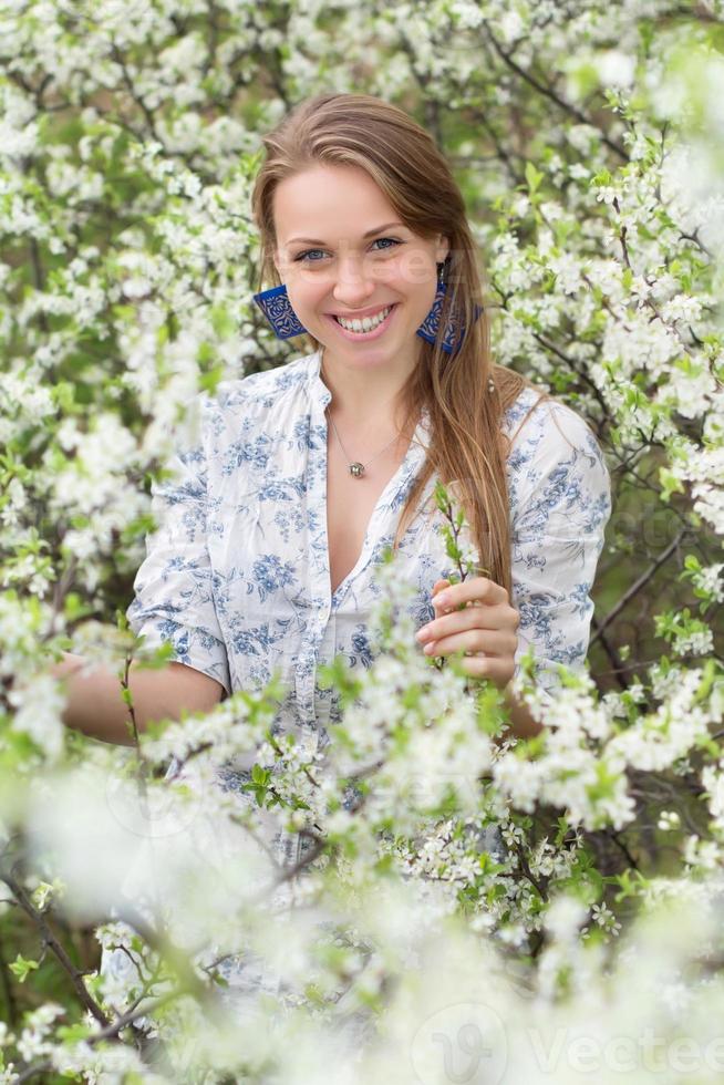 lächelnde Blondine im blühenden Garten foto