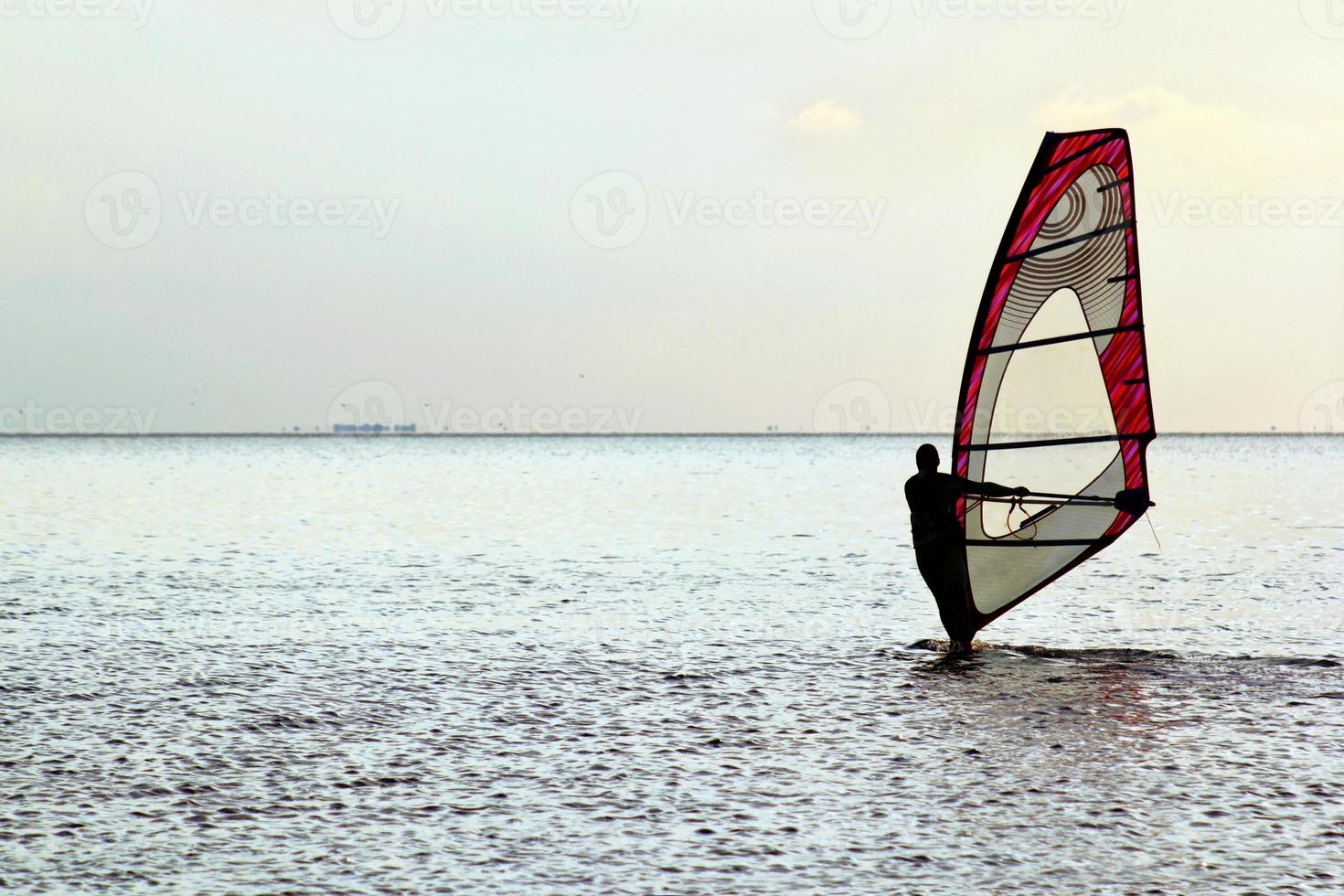 Mann Windsurfer über den Sonnenuntergang foto