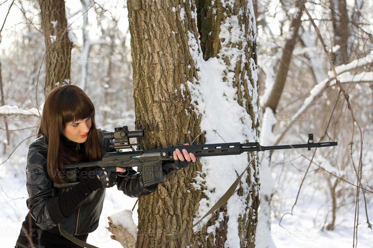schöne Frau mit einem Scharfschützengewehr foto