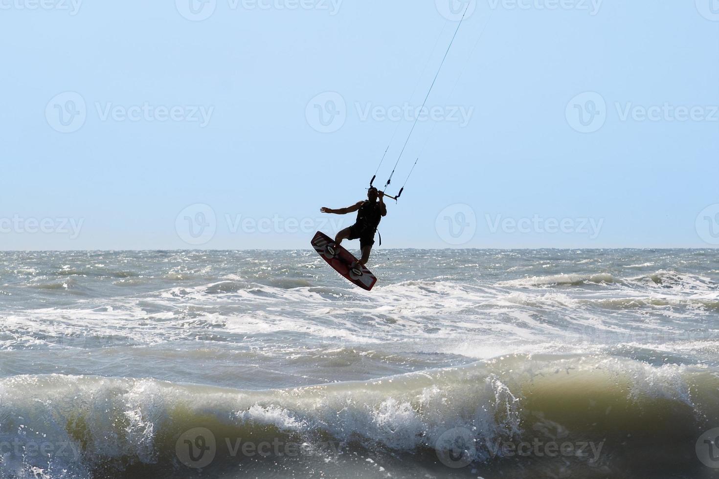 Kitesurfer-Silhouette, Springen und Fliegen foto