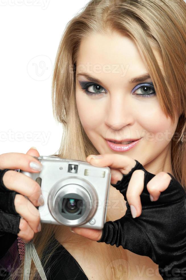 lächelnde schöne Frau, die eine Fotokamera hält foto