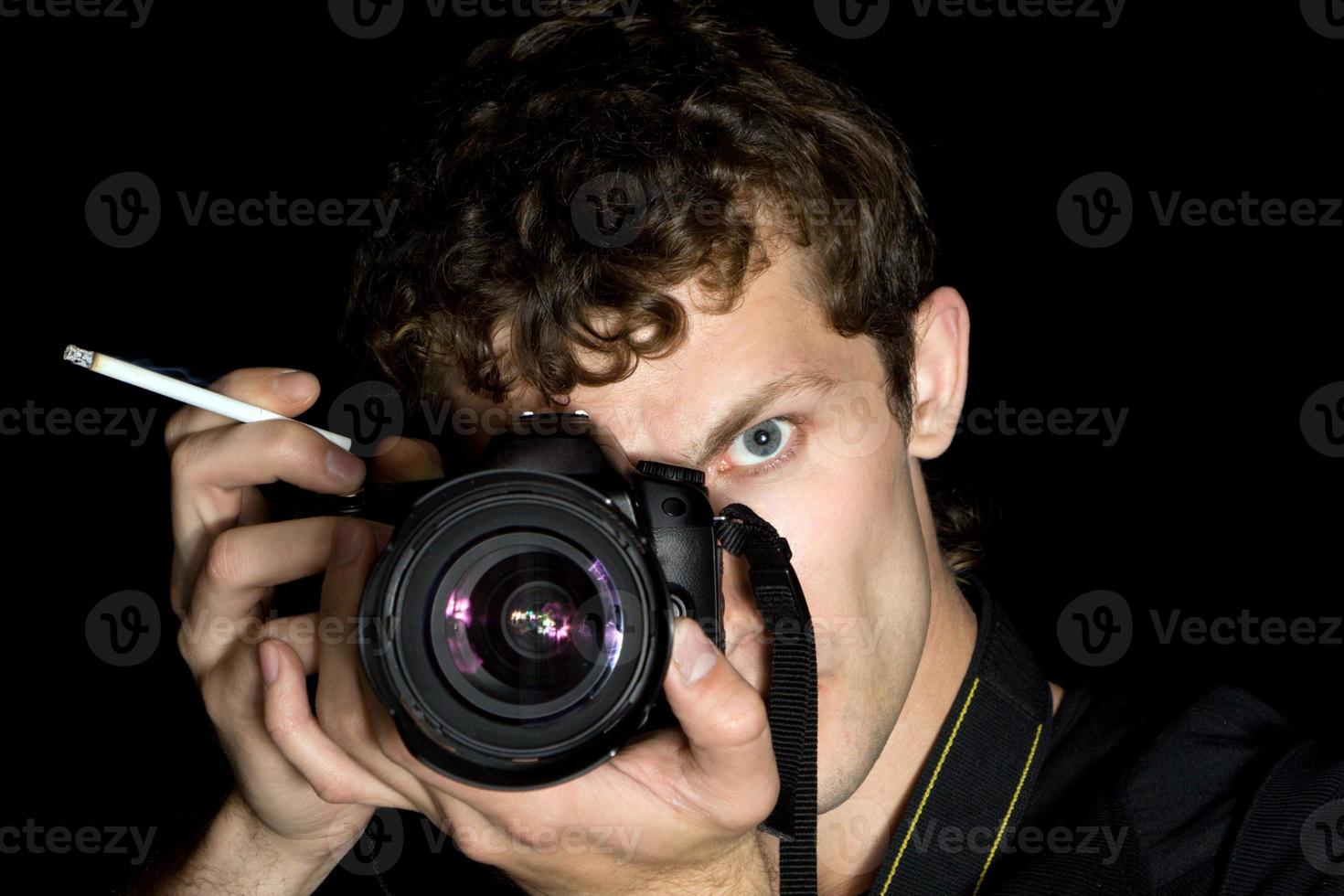 der junge mann - der fotograf hinter der arbeit. isoliert auf schwarzem Hintergrund 3 foto