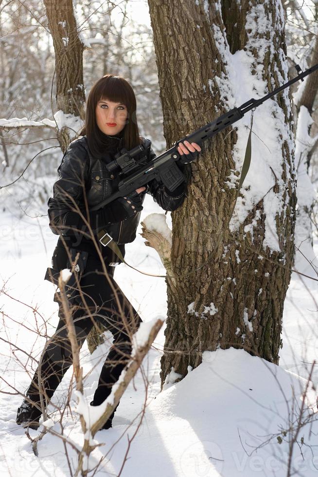 junge Frau mit einem Scharfschützengewehr foto