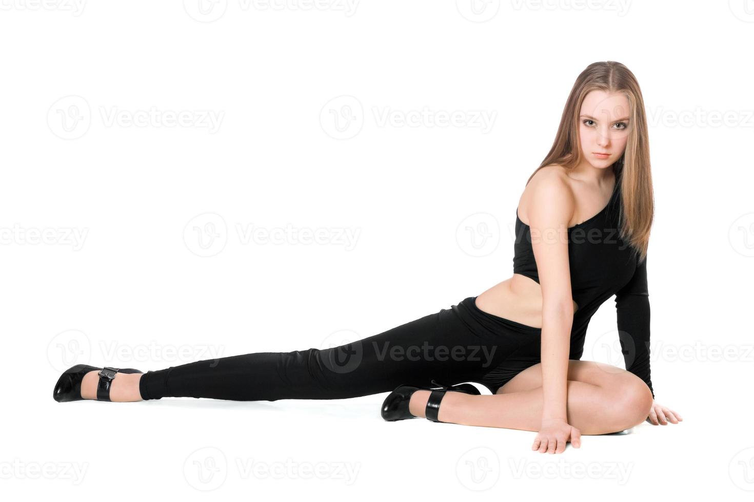 sexy junge Frau in einem schwarzen eng anliegenden Ganzkörperanzug tanzt foto