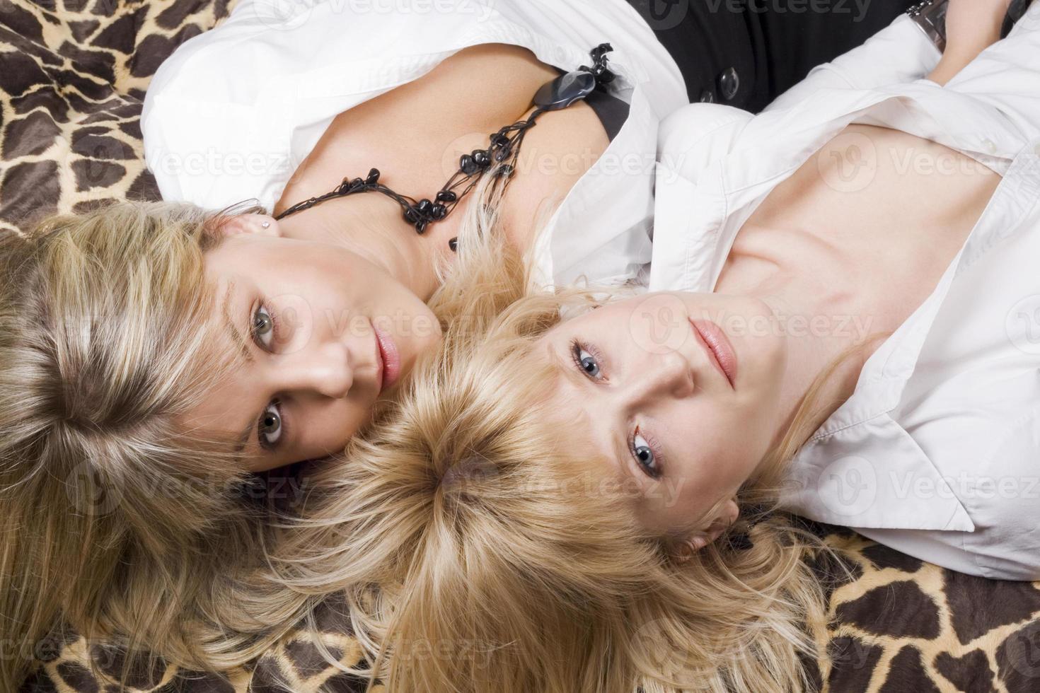 zwei junge blonde Schönheit liegt auf einem Bett foto