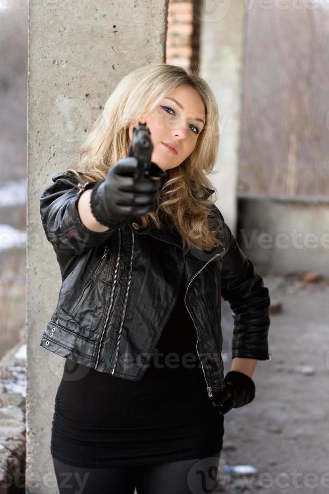 arrogante junge Frau mit einer Waffe foto