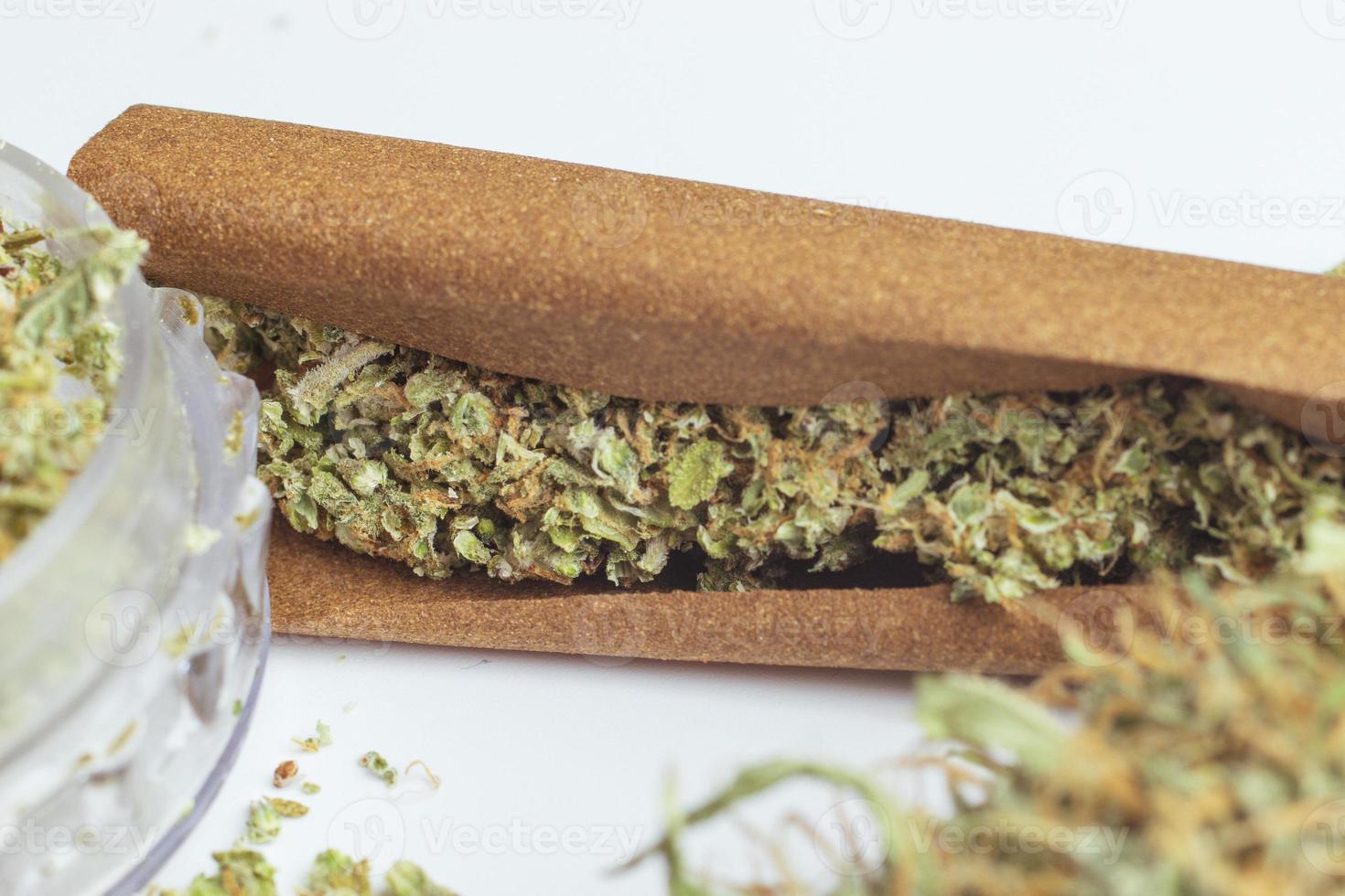 zerbröckelte medizinische Cannabisknospen in stumpfem Papier aus nächster Nähe. legales Marihuana rauchen. Unkraut Lebensstil foto