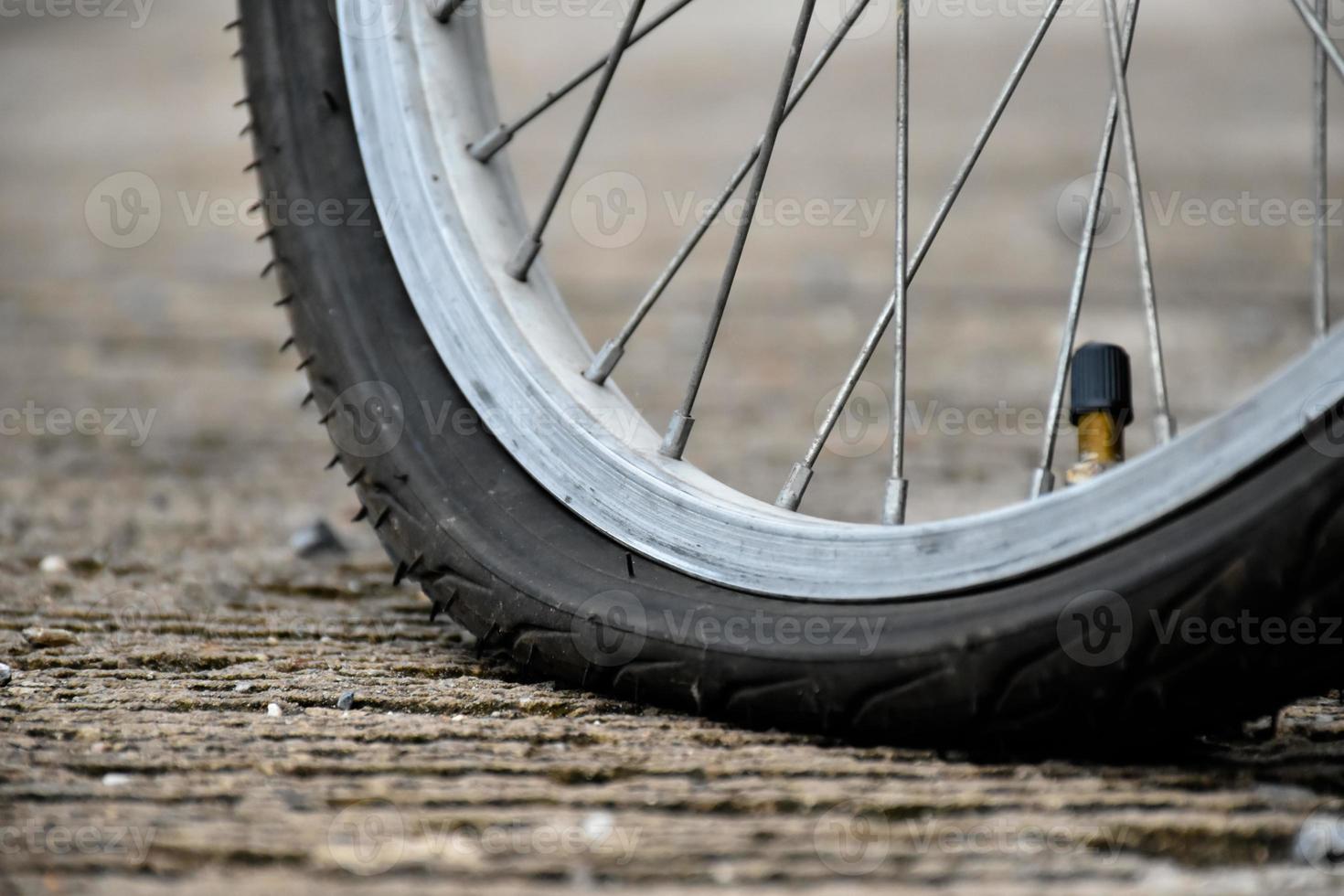 Nahaufnahme des platten Rads oder Fahrradreifens, das an der Straße geparkt ist und darauf wartet, repariert zu werden. foto