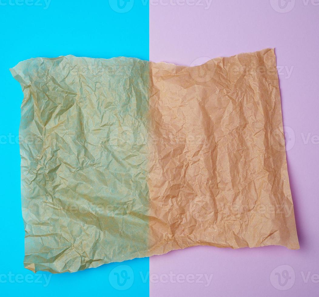 zerrissene braune Stücke Pergamentpapier auf einem blauvioletten Hintergrund foto
