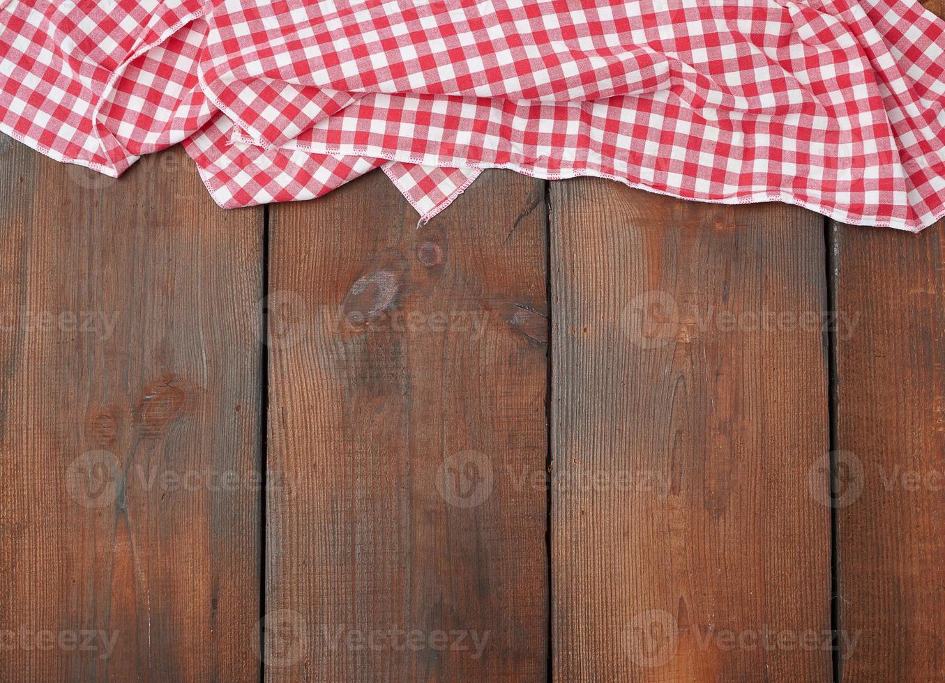 weiß rot kariertes Küchentuch auf braunem Holzhintergrund foto