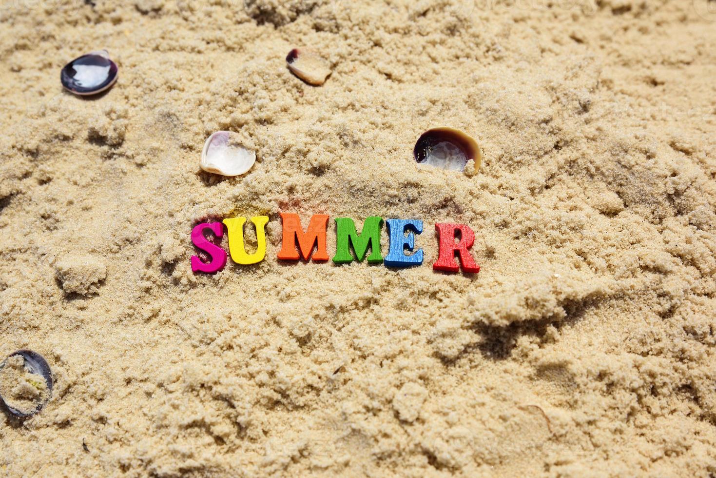 Inschrift Sommer auf Sand mit Muscheln foto