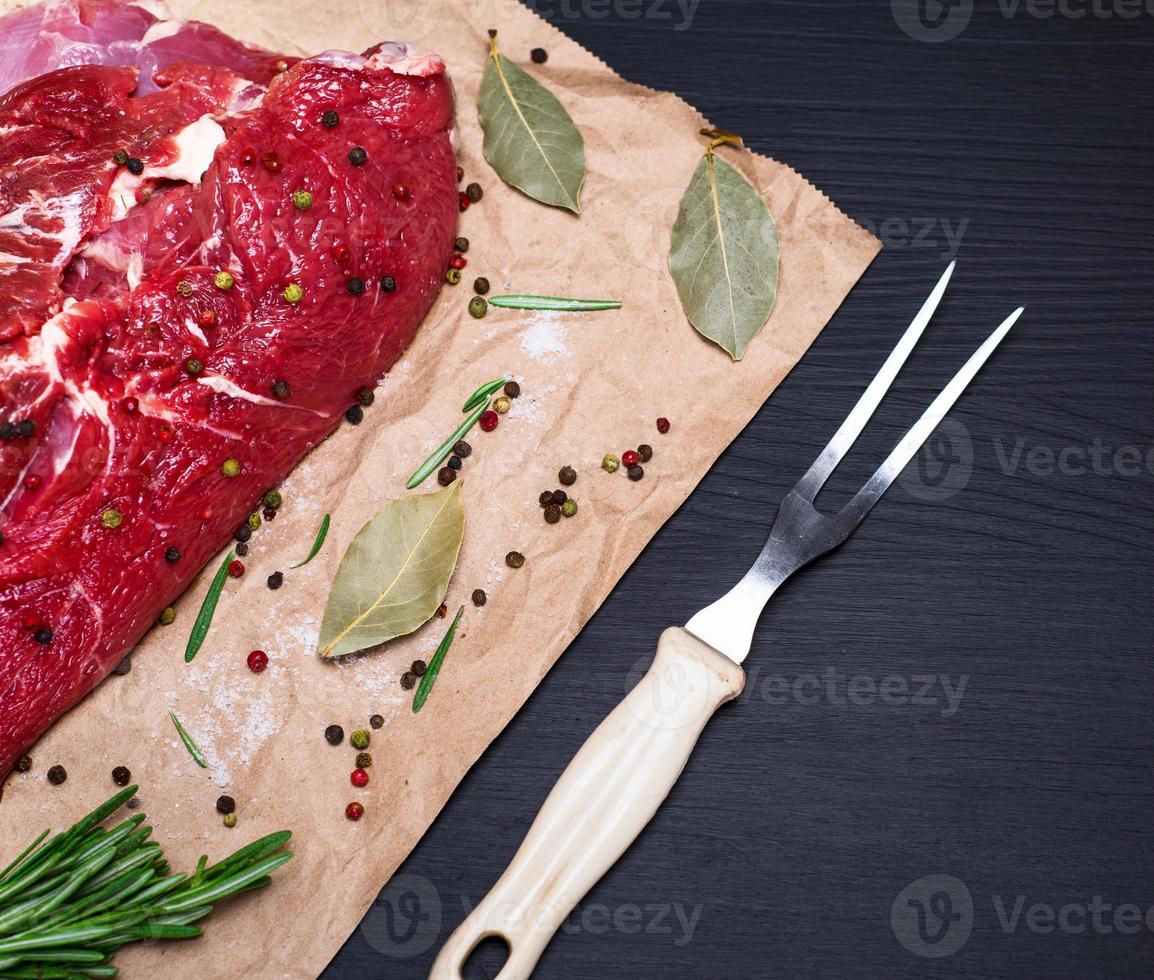 Rinderfilet auf braunem Kraftpapier und einer Küchengabel foto