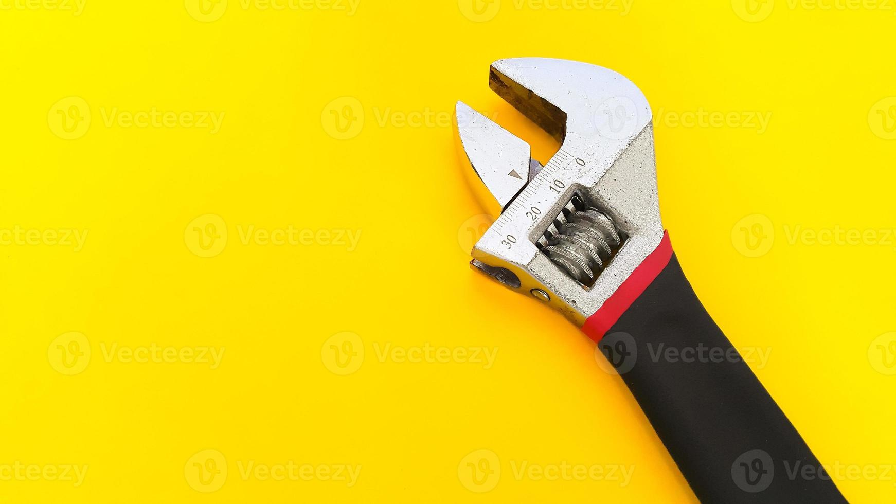 verstellbarer Schraubenschlüssel oder verstellbarer Schraubenschlüssel isoliert auf gelbem Hintergrund foto