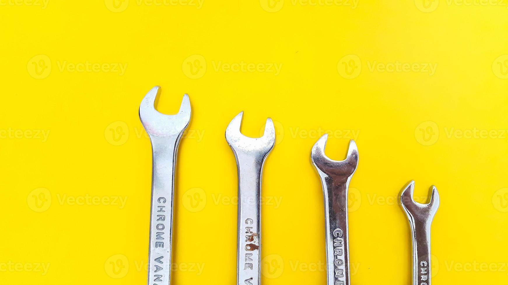 verschiedene Größen von Schraubenschlüsseln oder Schraubenschlüsseln isoliert auf gelbem Hintergrund. mechanisches Werkzeug. foto