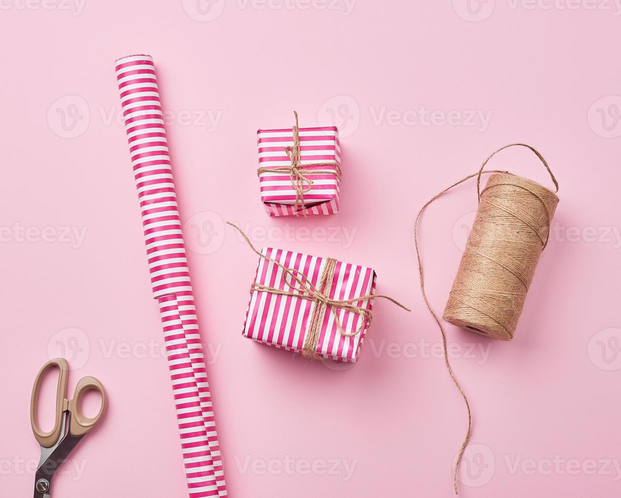 strang mit einem braunen seil, rolle mit weihnachtsgeschenkpapier, schere foto