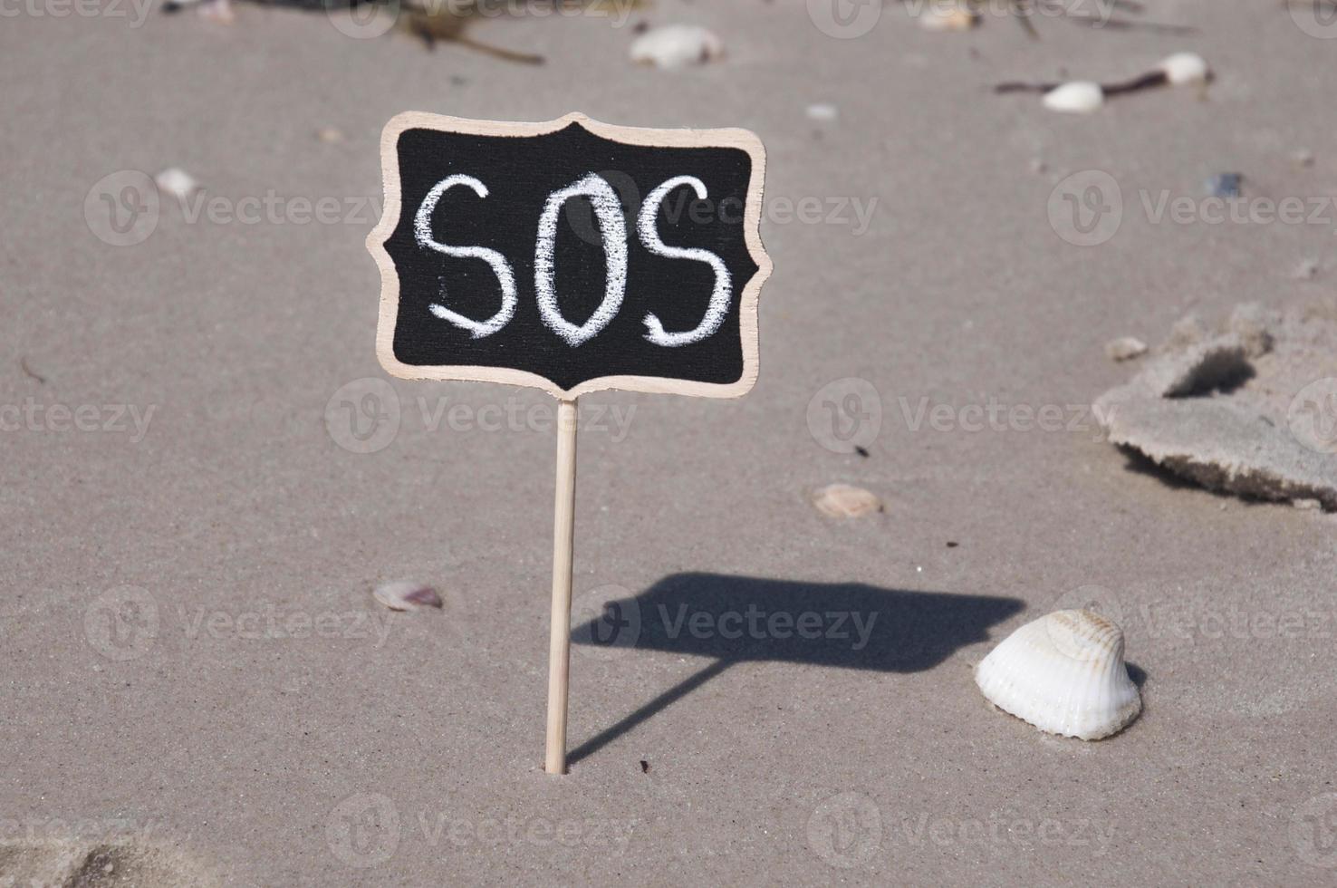 Holztafel am Strand mit Inschrift foto