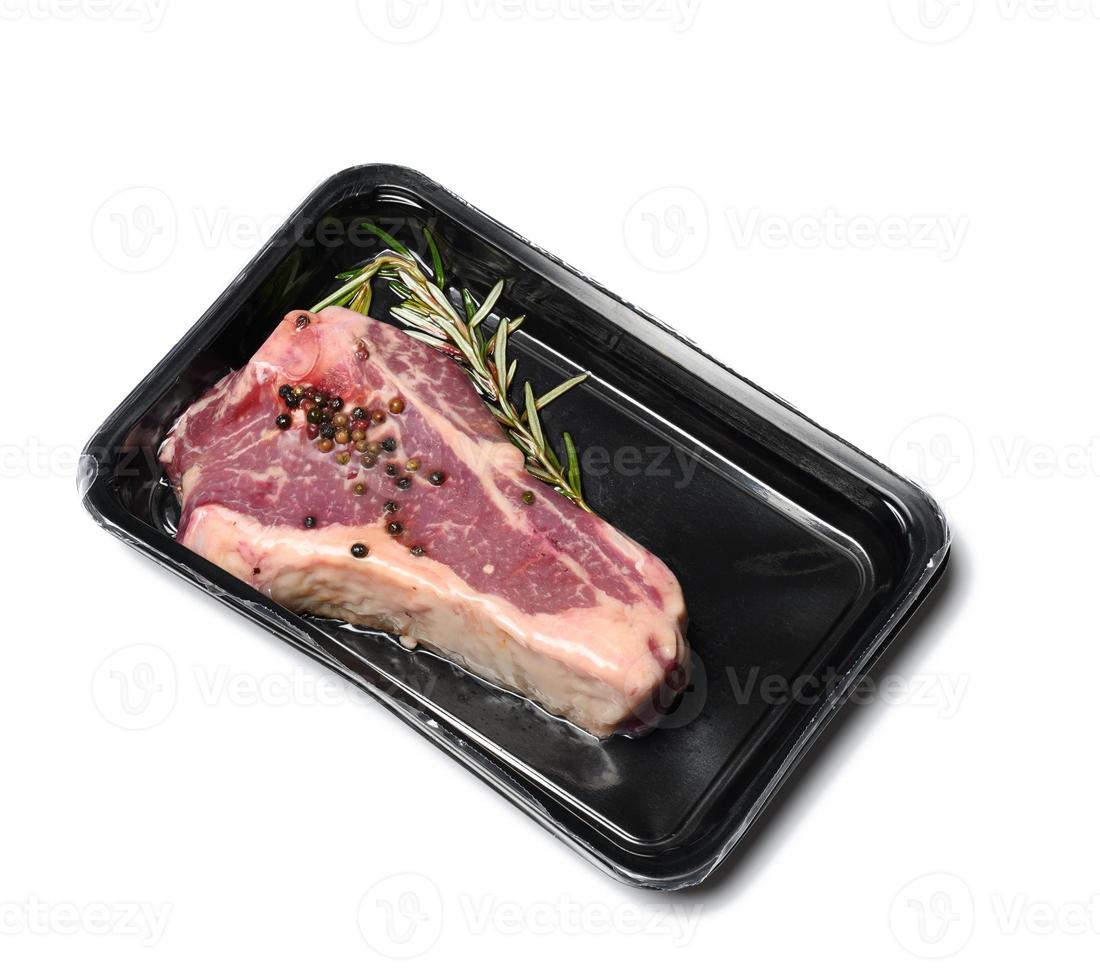 Raw New York Beef Steak wird in einem Plastikbehälter verpackt und vakuumversiegelt foto