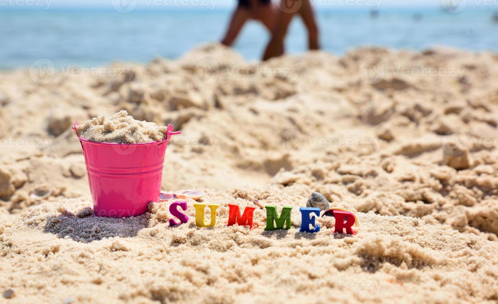 Inschrift Sommer auf dem Sand gegen das blaue Meer foto